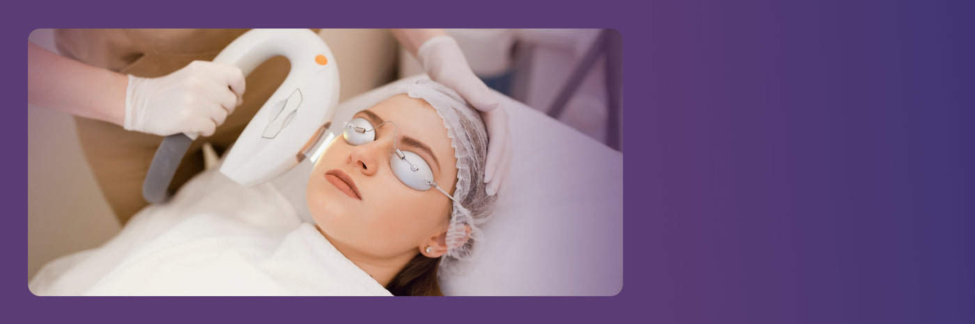 A person wearing protective goggles and a hair cap reclines while a technician, wearing gloves, uses a handheld laser device on their face. The scene is set against a purple background.