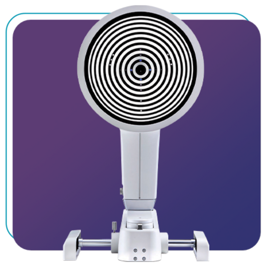 A concentric circular pattern device, likely an ophthalmic machine, is placed against a purple gradient background. The device features a circular front with black and white rings and a sturdy base.