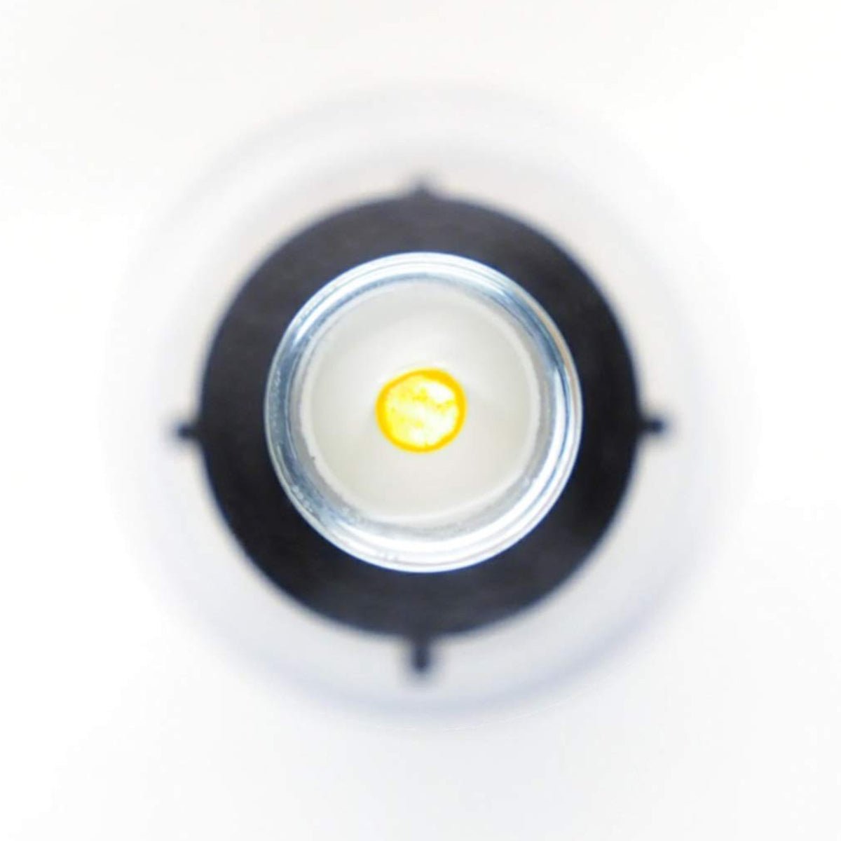 An overhead shot of the transparent S5 Mini Inserter by Augmented Vision Labs shows a small yellow dot at the base, set against a blurred white background. This precise image of the open neck and inner contents resembles hands-free lens stabilization techniques. Free video training included.