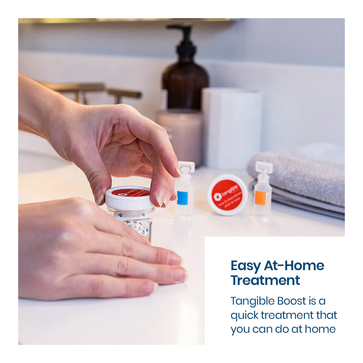 Hands hold a small jar of Tangible Boost, perfect for contact lenses care, alongside other eye products on a bathroom counter. A text reads, Easy At-Home Treatment with Tangible Boost 2-Pack—restore and maintain your Tangible Hydra-PEG coated lenses quickly at home.