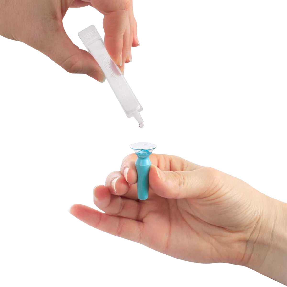 A person uses a blue applicator to hold a contact lens while dropping Visionary Optics Vibrant Vue Saline Lens Rinse and Insertion Fill Solution from a vial onto the lens, against a white background.