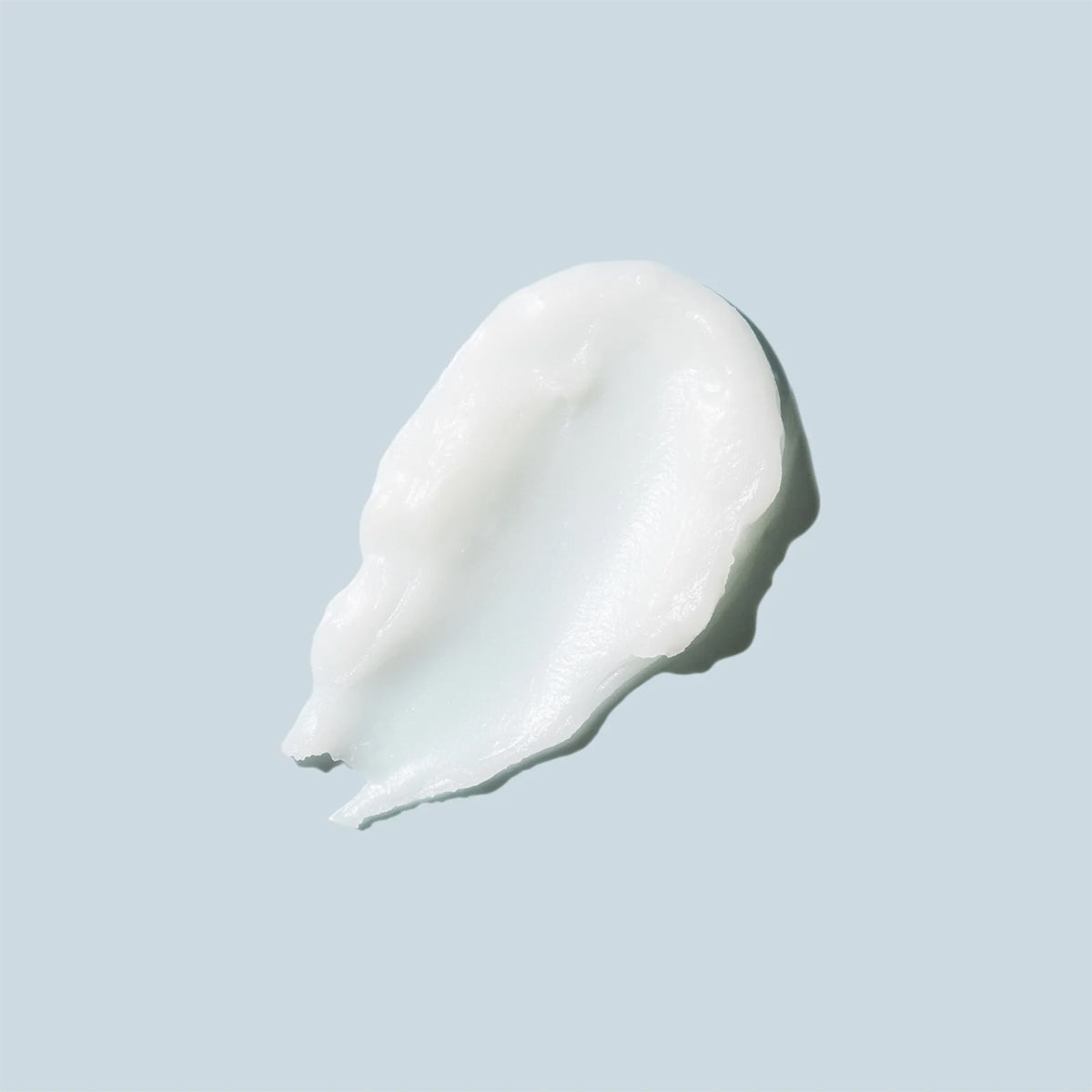 The Daily Practice Nourishing Makeup Melting Balm, known for its smooth texture, is elegantly displayed against a pale blue background.