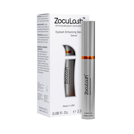 A cylindrical silver tube of ZocuLash Eyelash Enhancing Serum (2.5mL) by Zocular stands in front of its box, showcasing product details and branding. The packaging highlights the Tripeptide Lash Complex and notes its made in the USA to promote lash health.