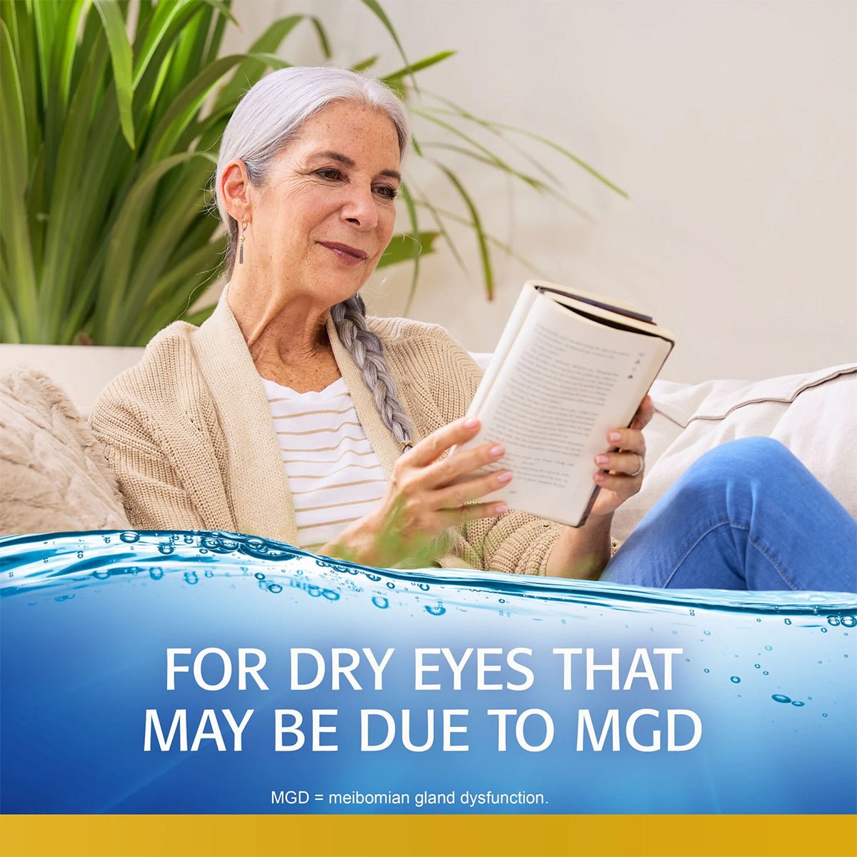 A gray-haired woman smiles on a couch with a book. Text reads, FOR DRY EYES THAT MAY BE DUE TO MGD (meibomian gland dysfunction). A cozy throw and plants complement the scene, promoting lipid-enhanced relief with Abbvies Refresh Optive Mega-3® Preservative-Free Eye Drops.