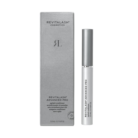 A silver RevitaLash box sits next to a tube labeled RevitaLash Advanced PRO Eyelash Conditioner and Enhancing Serum (3.5mL 6 Mo.Supply). Minimalist packaging with black text details its lash-enhancing formula, featuring the sleek RevitaLash logo.