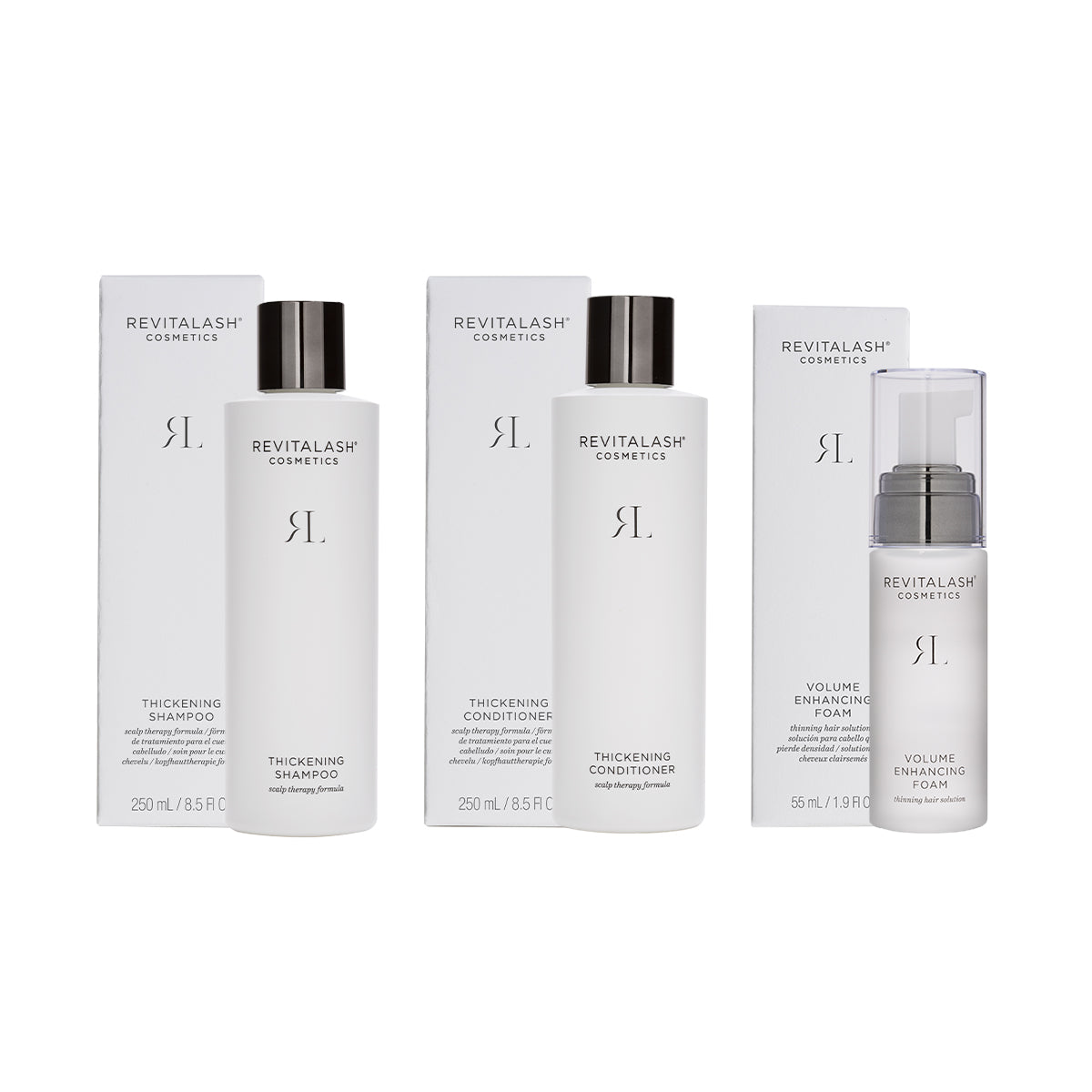The RevitaLash Volumizing Hair Collection Bundle includes biotin-enhanced shampoo, conditioner, and volume-boosting foam. These products are elegantly showcased in front of their matching boxes against a clean white background.