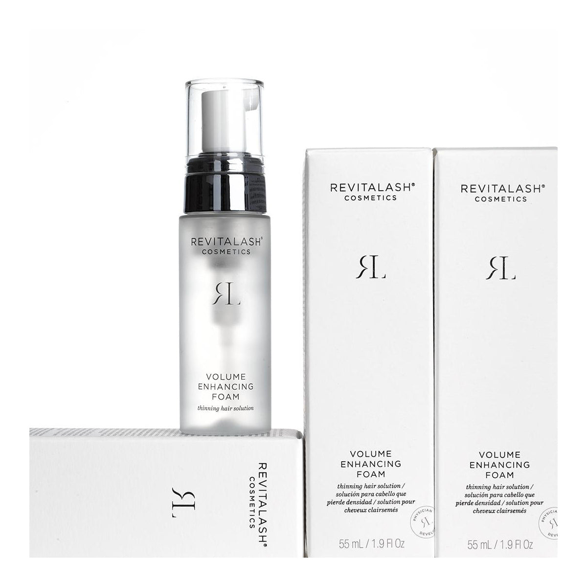 A bottle of RevitaLash Volume Enhancing Foam for Hair (55mL), infused with BioPeptin Complex, sits beside its sleek packaging. The predominantly white design with black text elegantly highlights each container, making it a standout hair enhancer choice.