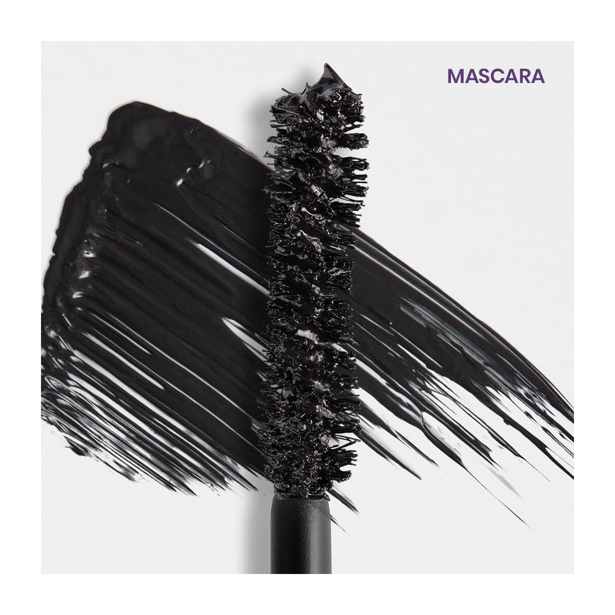 A close-up of a black wand from the RevitaLash Double-Ended 2-in-1 Lash Primer & Mascara Volume Set sits against a white background, with a stroke of volumizing product artfully smeared beside it. MASCARA is elegantly printed in purple at the top right corner.