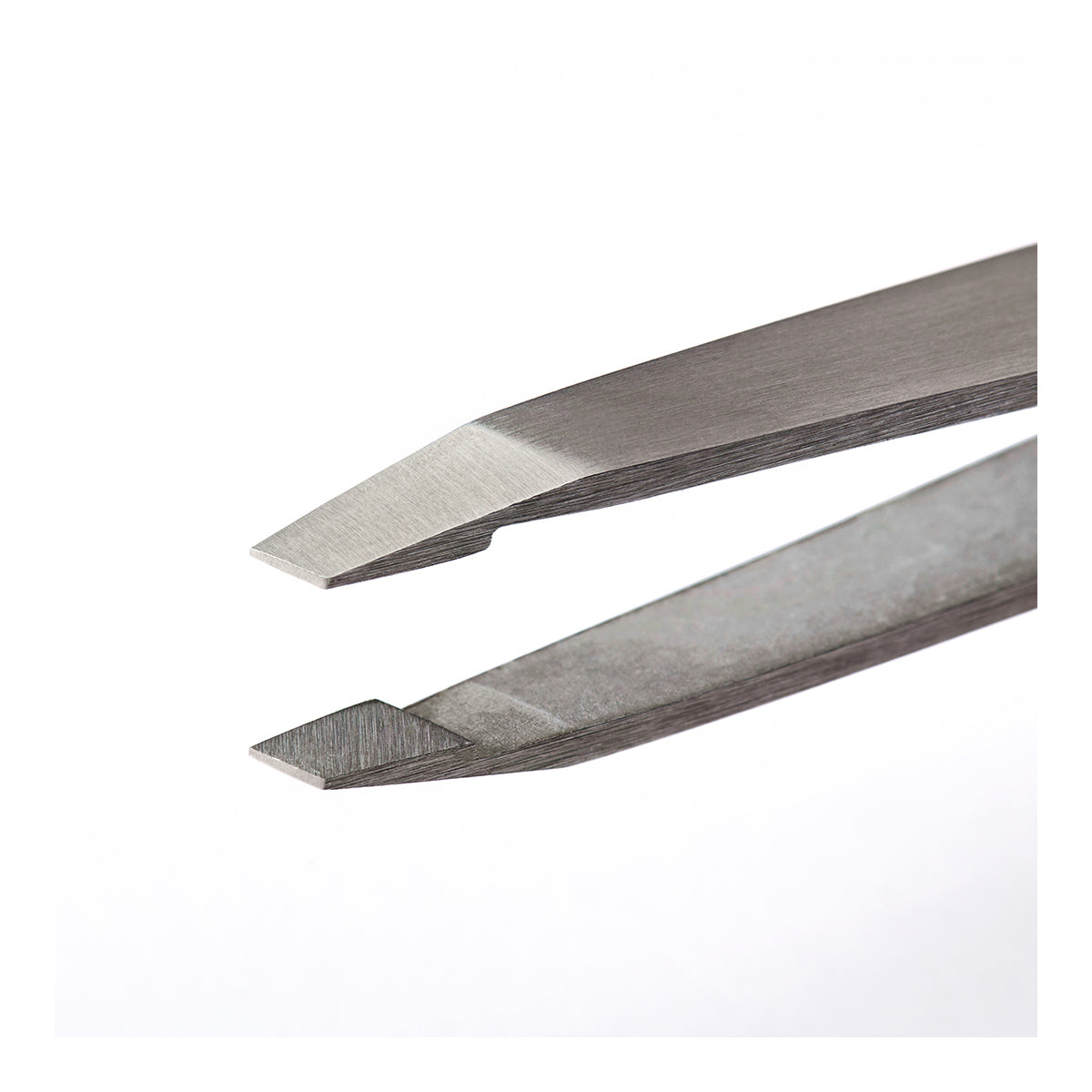 Close-up of two pointed RevitaLash Precision Tweezers on a white background. The stainless steel tips are aligned for precision tasks, showcasing fine edges. The tweezers are slightly open, emphasizing their sharpness and functionality for perfect arched brows.