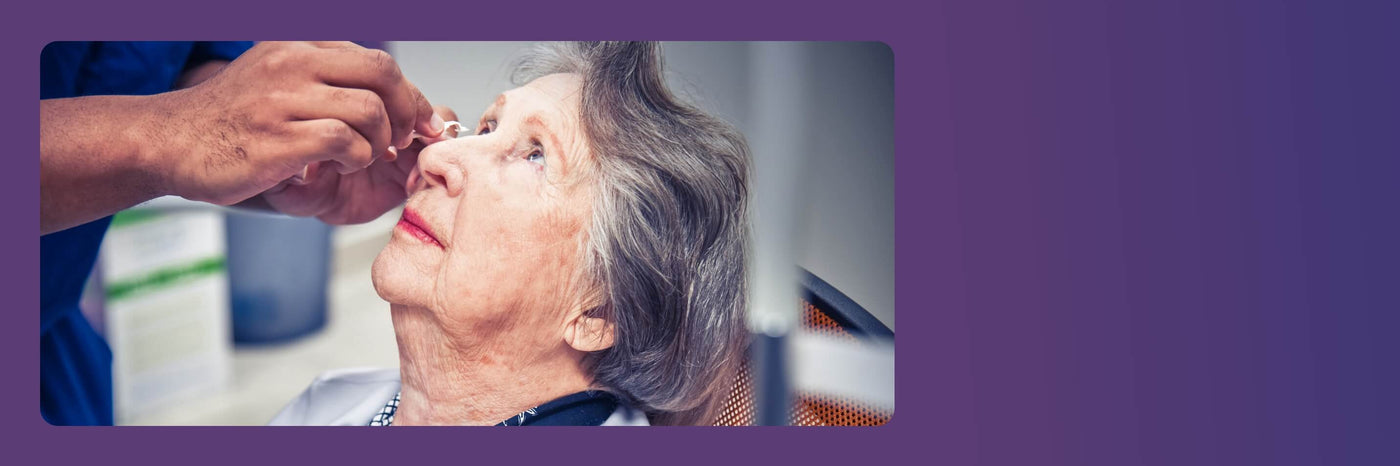 A healthcare professional is administering eye drops to an elderly woman seated in a medical setting. She looks up while the professional gently holds her head. The background is softly blurred, and the image has a purple border on the right.