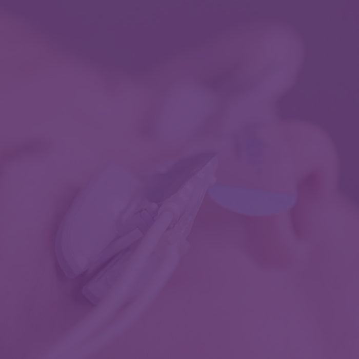 Close-up image of a person wearing a medical earpiece with attached wires. The image is heavily tinted purple, obscuring details.