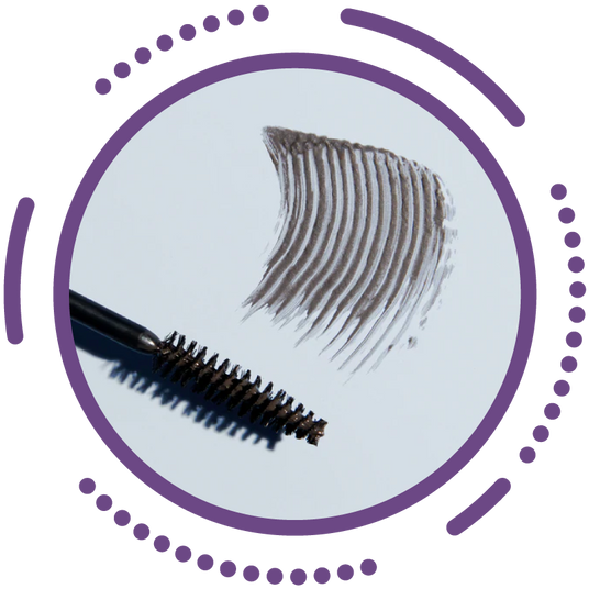 Mascara wand with dark strokes on a white surface, surrounded by a circular frame and dot patterns in purple.