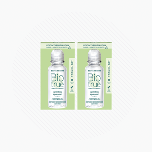 Two BioTrue Multipurpose Contact Lens Solution Travel Kits by Bausch + Lomb, each containing a 2 oz bottle, are set against a white background with subtle circular lines.