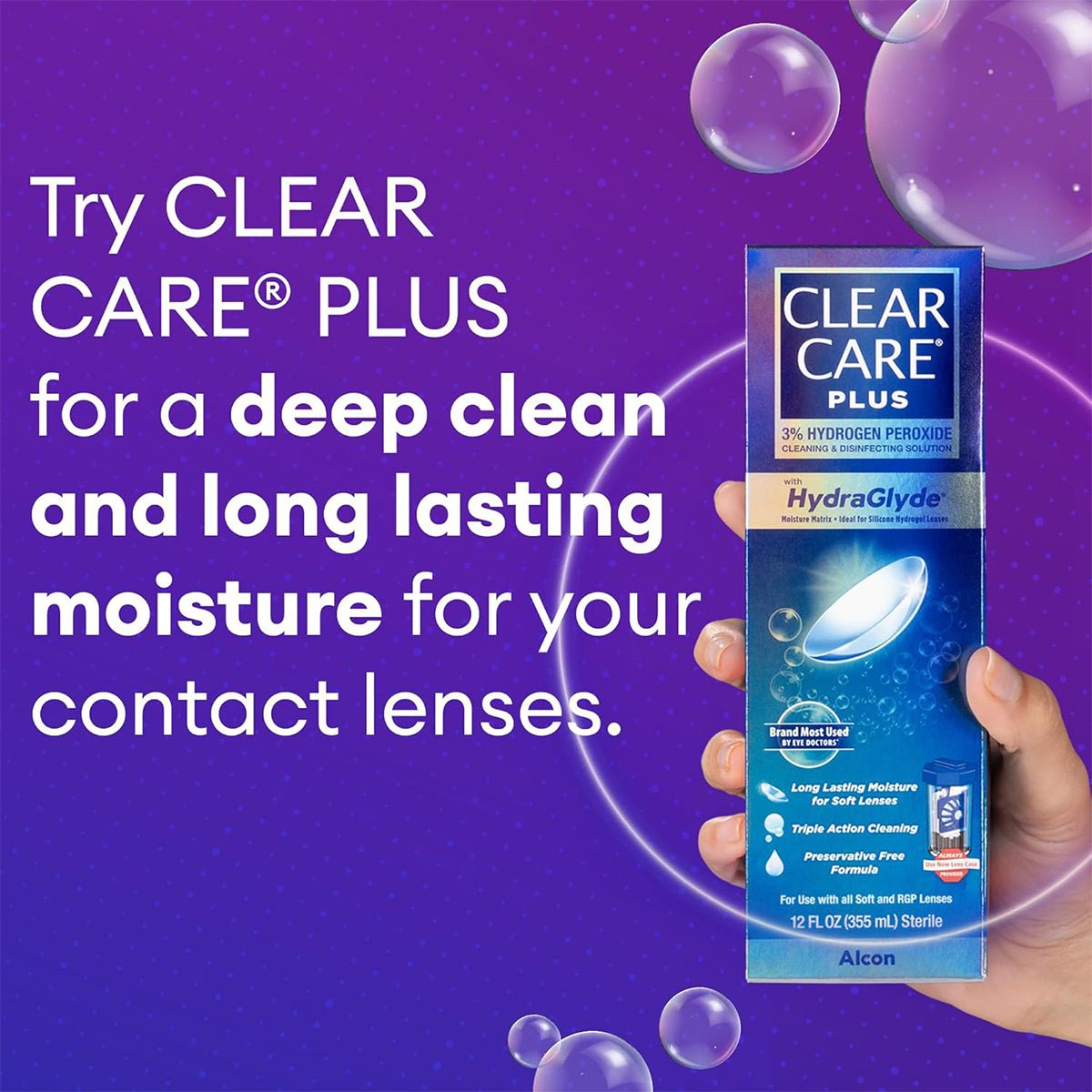 A hand holds the Clear Care Plus Cleaning Solution with Lens Case, 12 Oz Bottle by Alcon, featuring HydraGlyde for deep cleaning and lasting moisture for your contact lenses. Set against a purple bubble background, it emphasizes its preservative-free formula for optimal eye comfort.