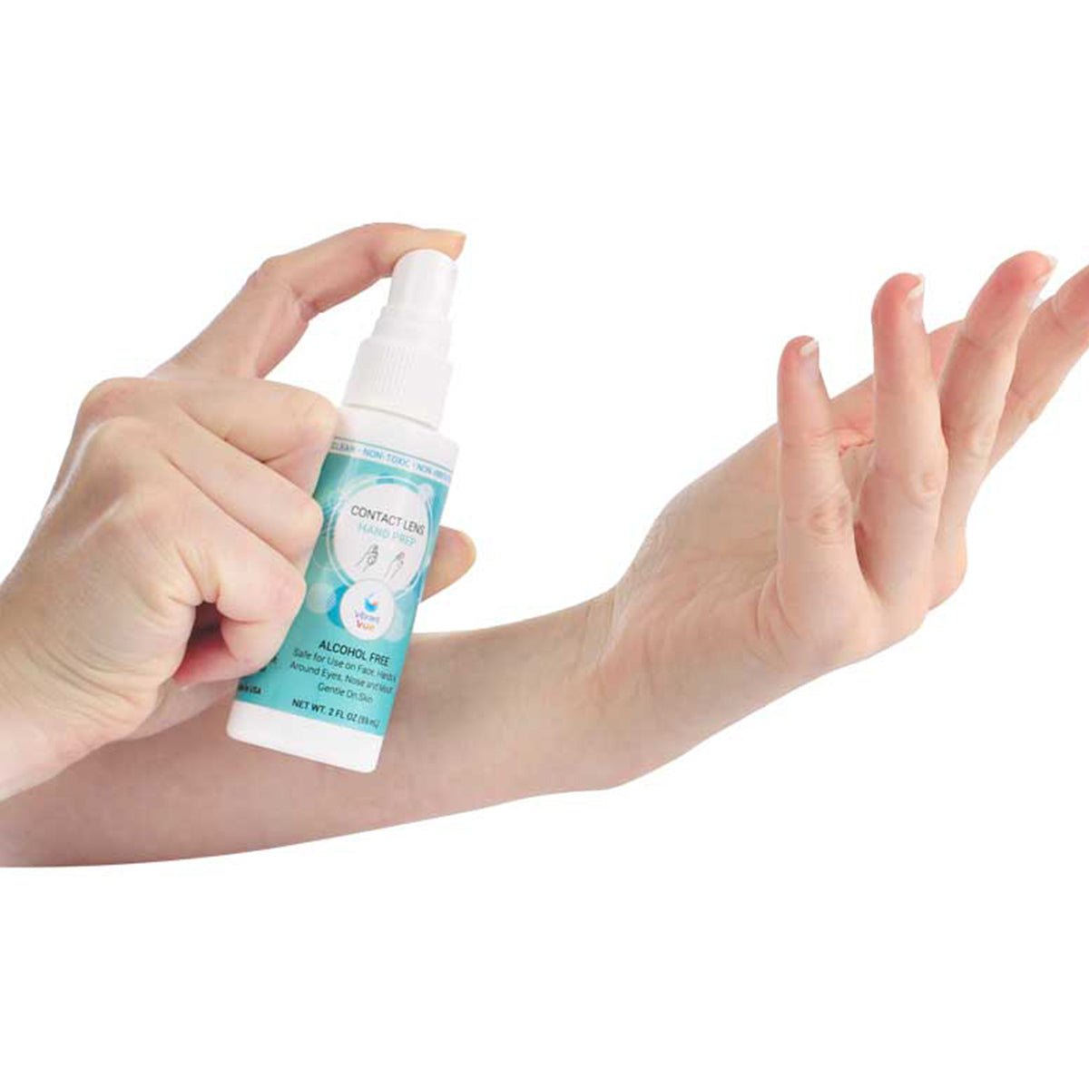 Close-up of a person using Vibrant Vue Contact Lens Hand Prep from Visionary Optics, spraying the white and teal bottle labeled Alcohol Free, releasing a fine mist containing hypochlorous acid onto their palm.