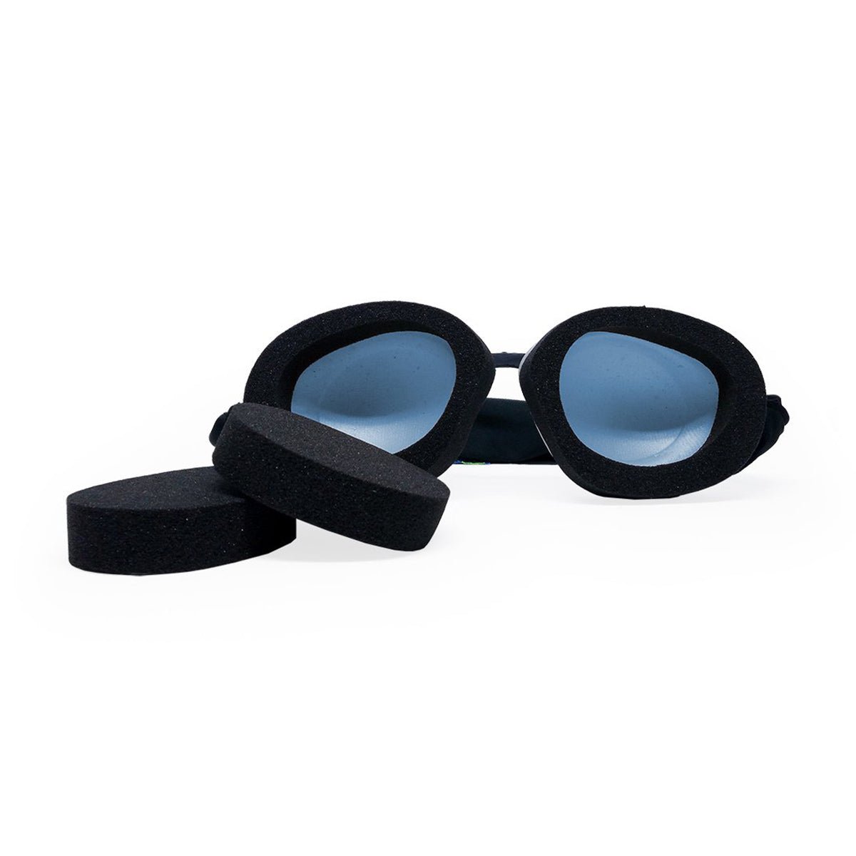 The Eyeeco Tranquileyes Mini from PRN features black swimming goggles with blue lenses. Displayed on a white background, the set includes two circular black foam pieces, perfect for dry eye therapy during swimming.