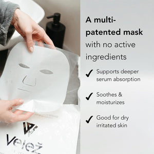 Close-up of hands holding a white, cut-out Velez Intense Hydration Cellulose Face Mask above its packaging. Text highlights benefits: Supports deeper serum absorption, Soothes & moisturizes, and Good for dry, irritated skin with biotech cellulose mask for enhanced hydration.
