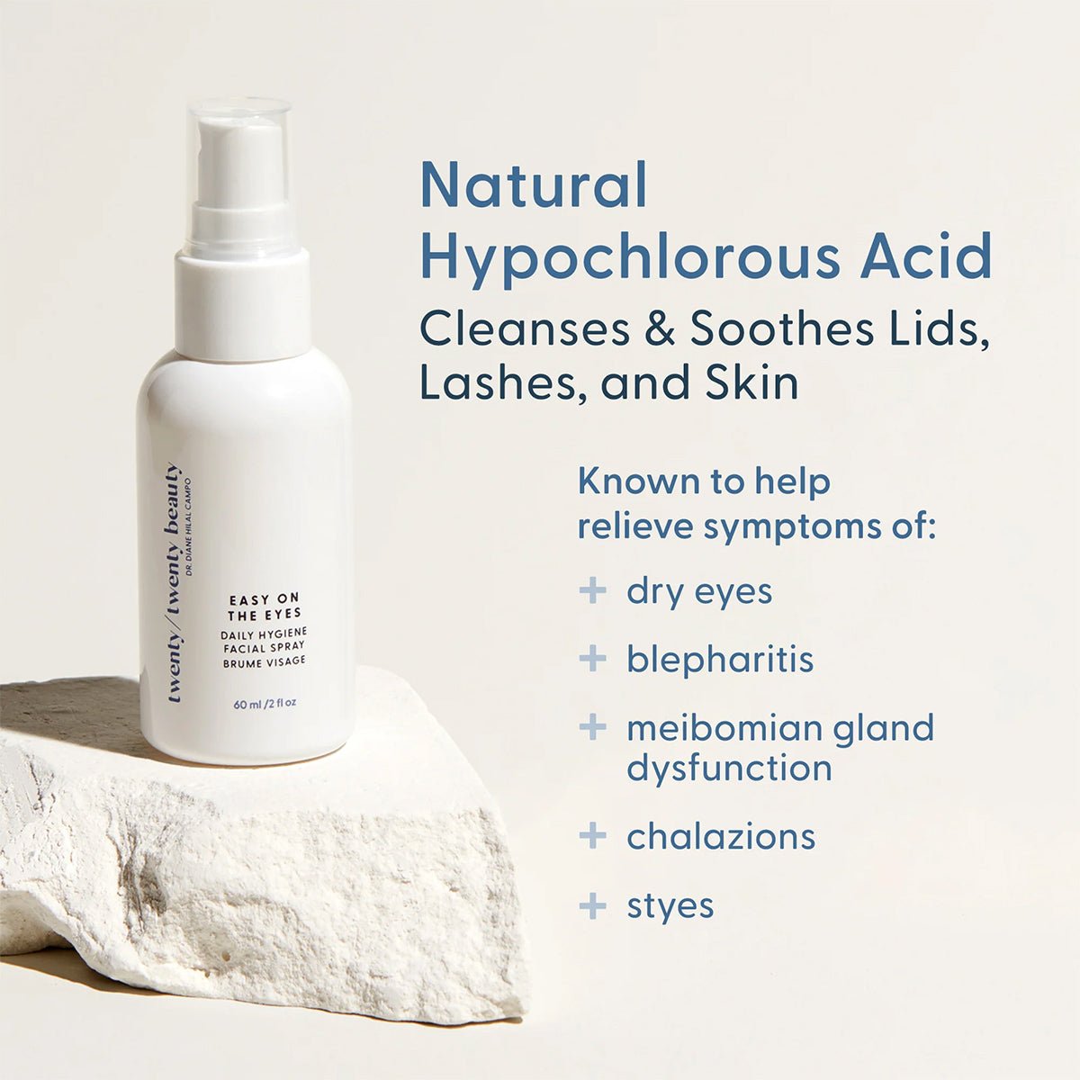 A white bottle of Twenty Twenty Daily Hygiene Facial Spray with hypochlorous acid rests on a stone, labeled: Natural Hypochlorous Acid for soothing dry eyes. Subheading highlights: Cleanses & Soothes Lids, Lashes, and Skin. An ophthalmologist-developed calming remedy by Twenty Twenty.