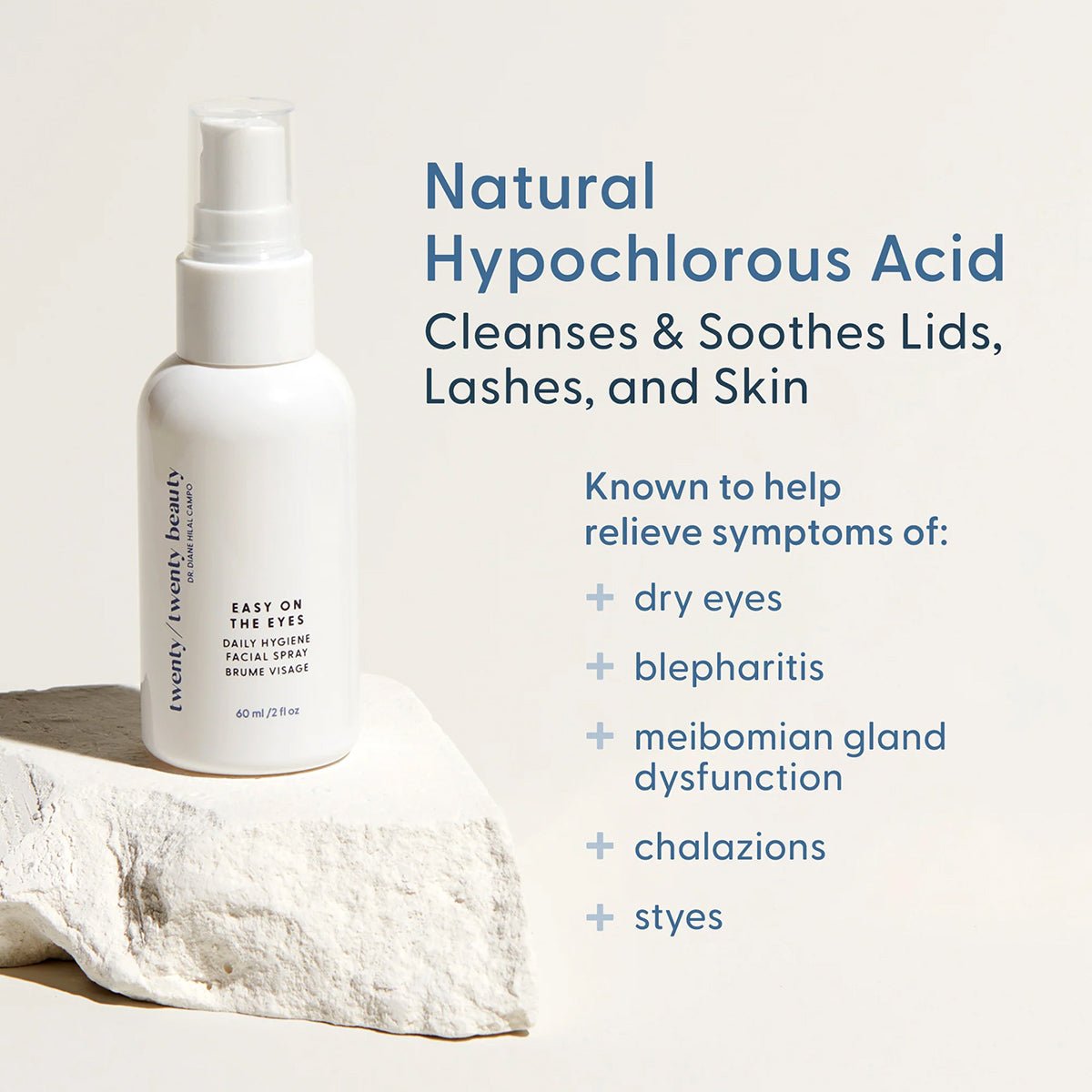 A spray bottle labeled Easy on the Eyes from Twenty Twenty sits on a stone platform. Text beside it reads: Natural Hypochlorous Acid. Cleanses & Soothes Lids, Lashes, and Skin. Ideal for ocular health, it alleviates dry eyes, blepharitis, gland dysfunction, chalazions, and styes.