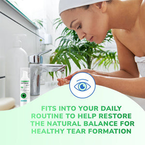 A woman wrapped in a towel, wearing a headband, washes her face at a sink. Beside her is Optase Tea Tree Oil Eye Lid Cleansing Gel (50mL), which supports tear formation. The tranquil bathroom setting with greenery enhances this serene eyelid hygiene ritual.