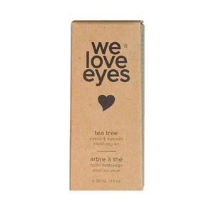 A rectangular box features we love eyes in bold black with a heart icon, highlights the benefits of Tea Tree Oil for eyelid skin, and mentions eyelid & eyelash cleansing oil in English and French. Volume: 30 mL / 1 fl oz. Product: We Love Eyes- All Natural Tea Tree Eyelid Cleansing Oil - 30ml.
